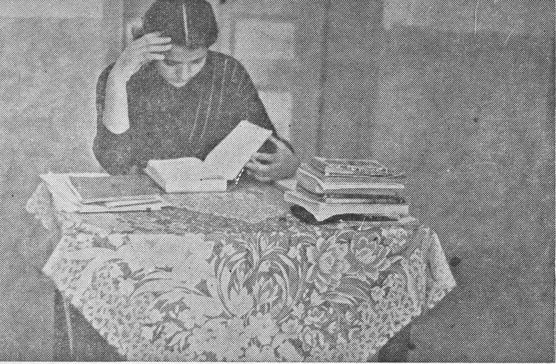 امرأة تقرأ بين الكتب
